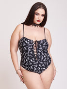 black one piece swim suit with a white all over print and lace up detail front and back middle